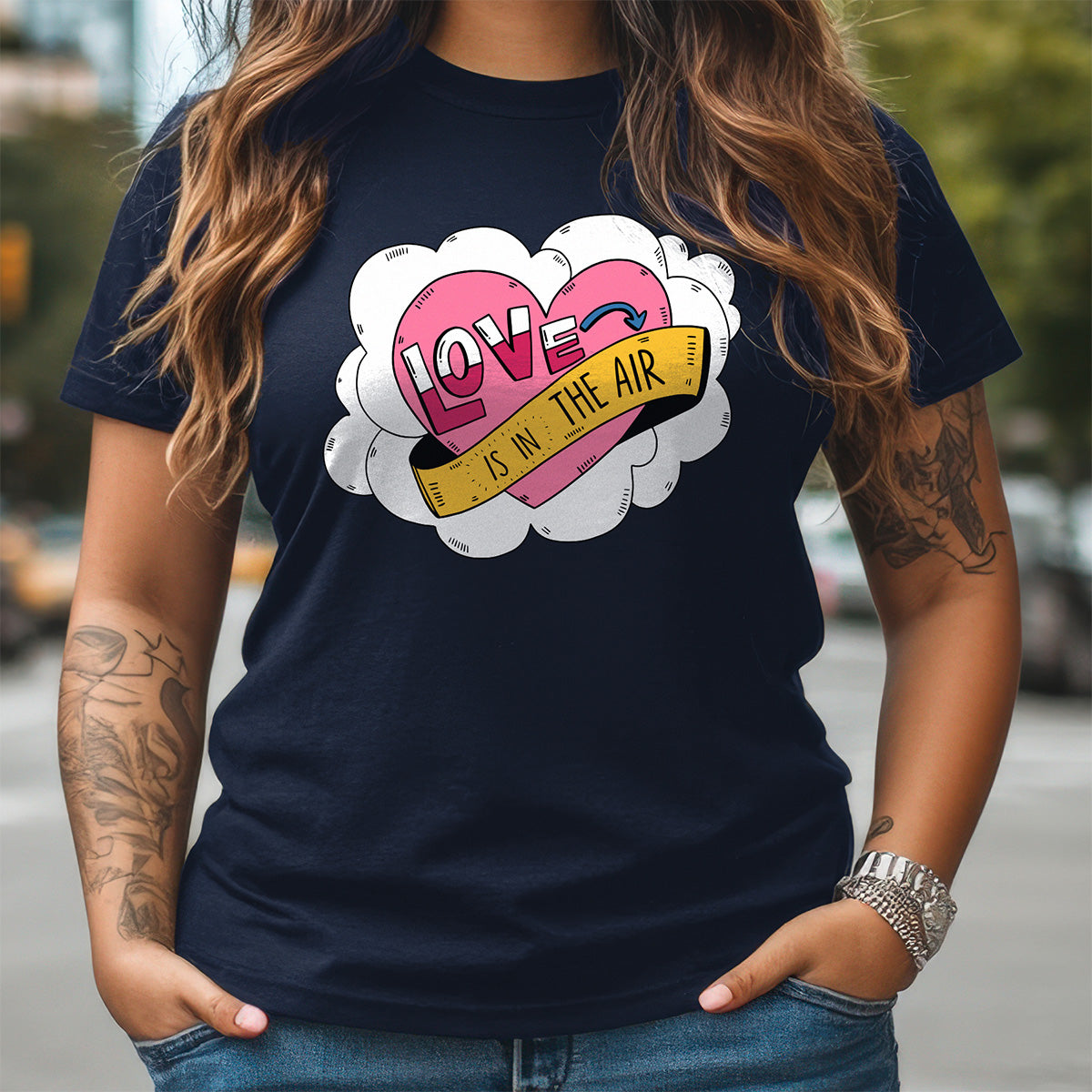 Person wearing a navy blue t-shirt with a colorful graphic design of hearts and text.