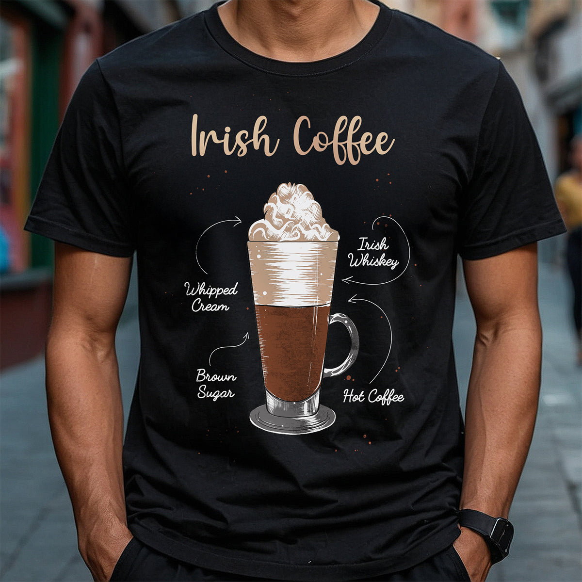 Person wearing a black t-shirt with an illustration of Irish coffee and text on a blurred street background