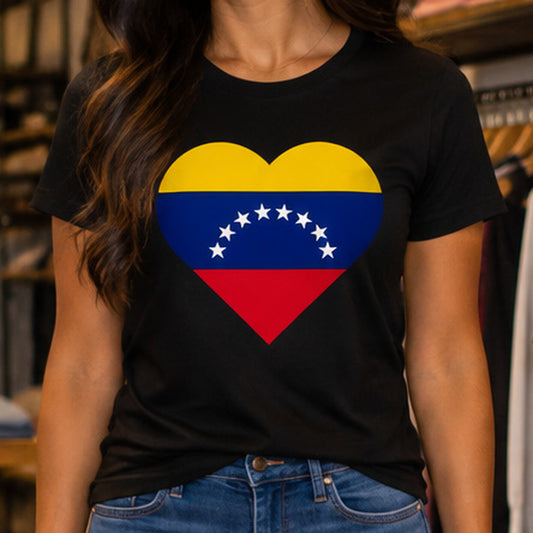 A woman wearing a black short-sleeve t-shirt with a heart-shaped graphic of the Venezuelan flag (yellow, blue, red with white stars) on the chest, paired with blue jeans.