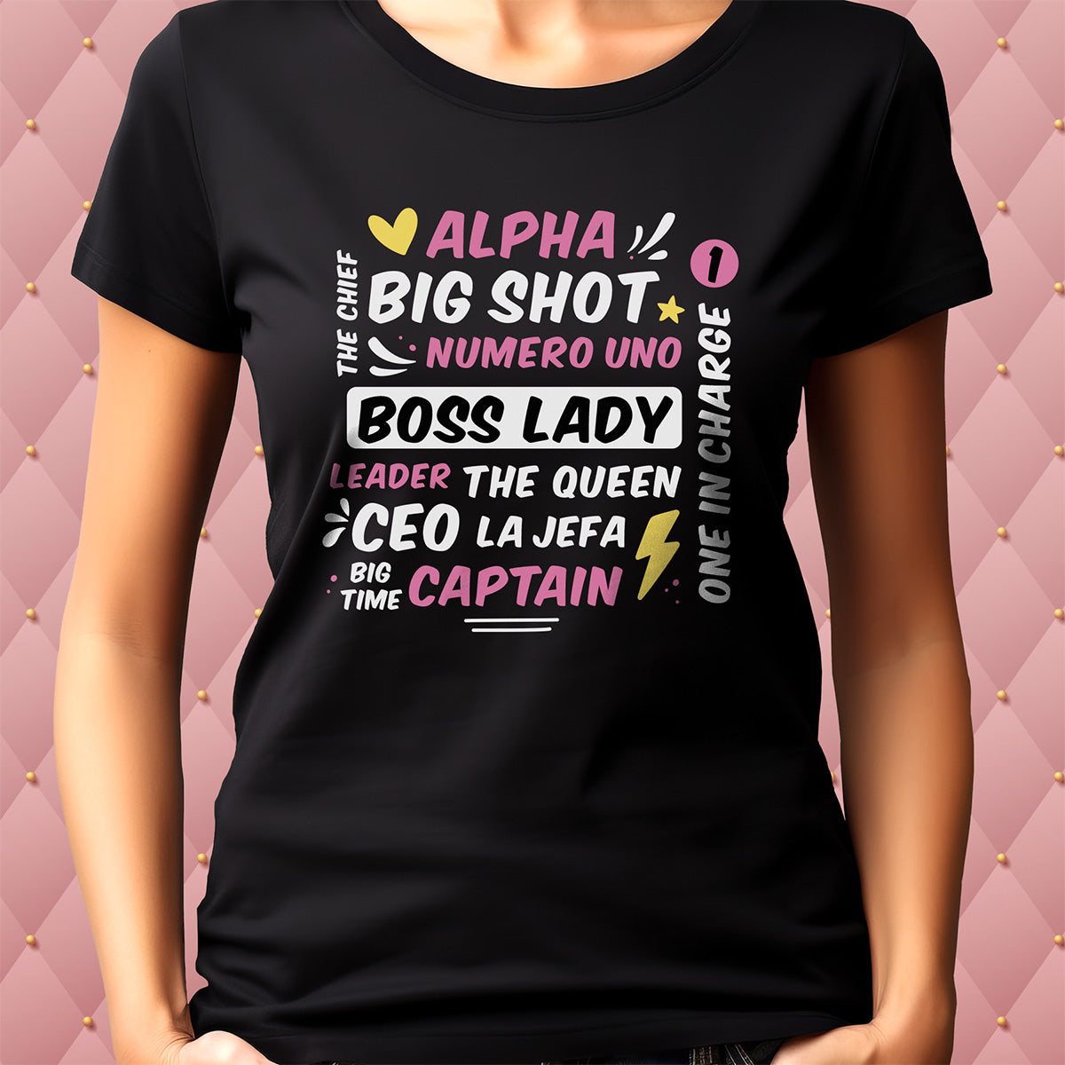 Black t-shirt with colorful text design on a pink quilted background