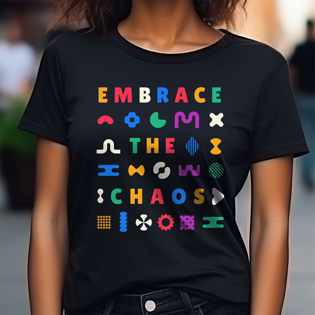 Person wearing a black t-shirt with colorful text and symbols on a blurred background